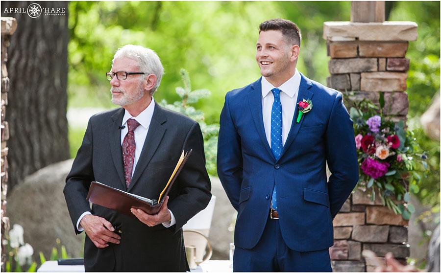 Groom-Smiles-when-he-sees-his-bride-for-the-first-time-on-their-wedding-day-at-Wedgewood-on-Boulder-Creek-in-Colorado.jpg