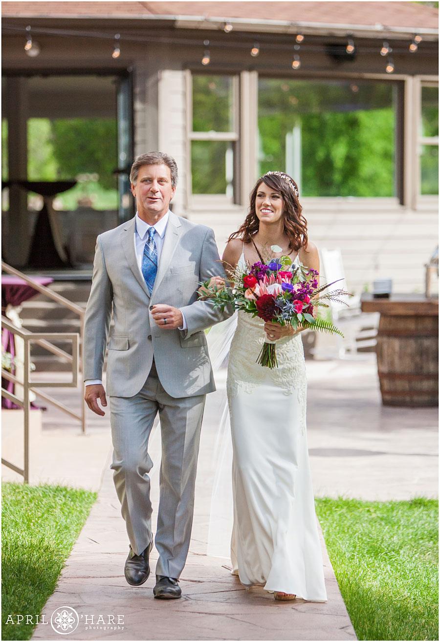 Bride-walks-down-the-aisle-with-her-dad-at-Wedgewood-on-Boulder-Creek-in-Colorado.jpg